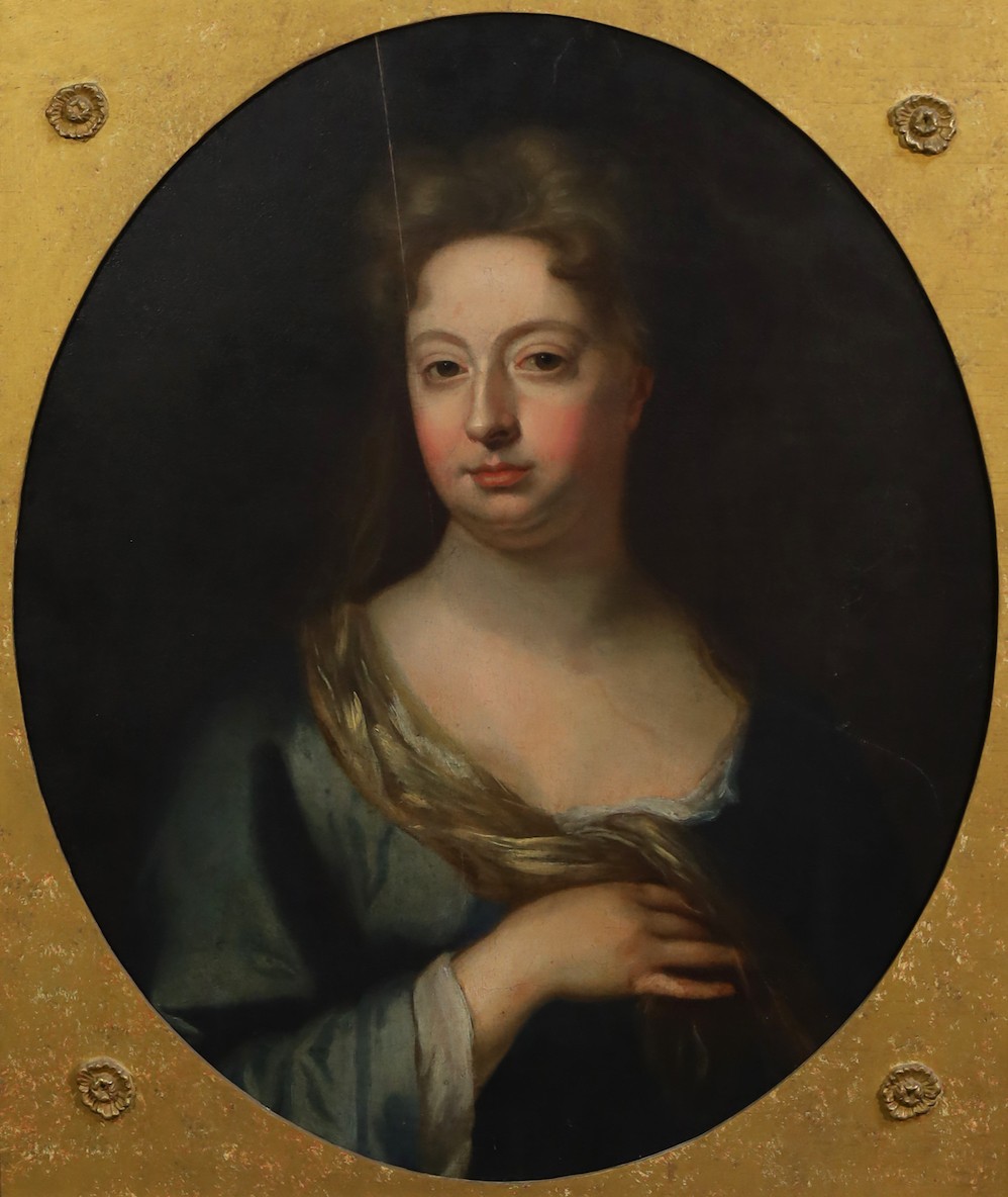 Circle of Sir Godfrey Kneller (British, 1646-1723), Portrait of a lady wearing a blue dress, oil on canvas, oval, 69 x 57cm